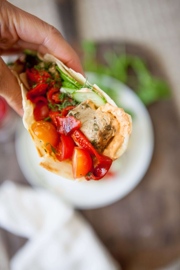 Hand holding harissa feta wrap.
