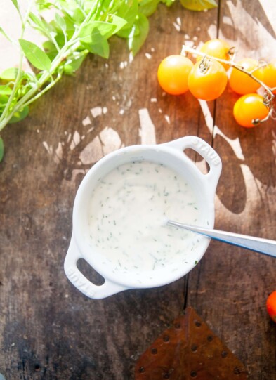 Buttermilk chive dip in small white bowl with spoon.