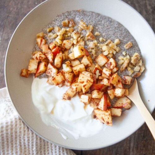 Apples, greek yogurt and chia pudding in a bowl with spoon.