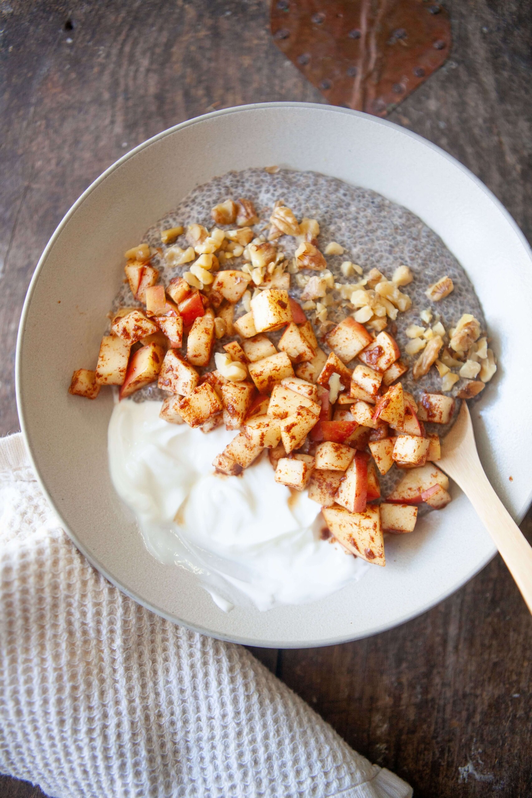 Apples, greek yogurt and chia pudding in a bowl with spoon.