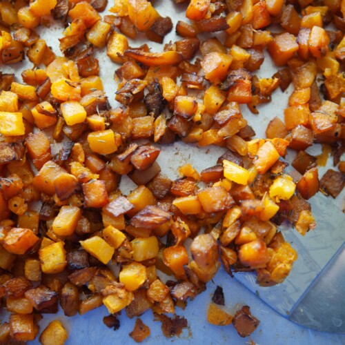 Butternut squash roasted on pan with spatula.