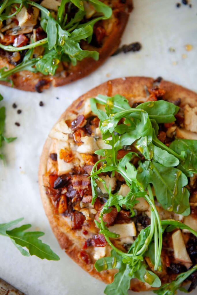 Butternut squash, bacon and caramelized onion flatbreads on baking sheet.