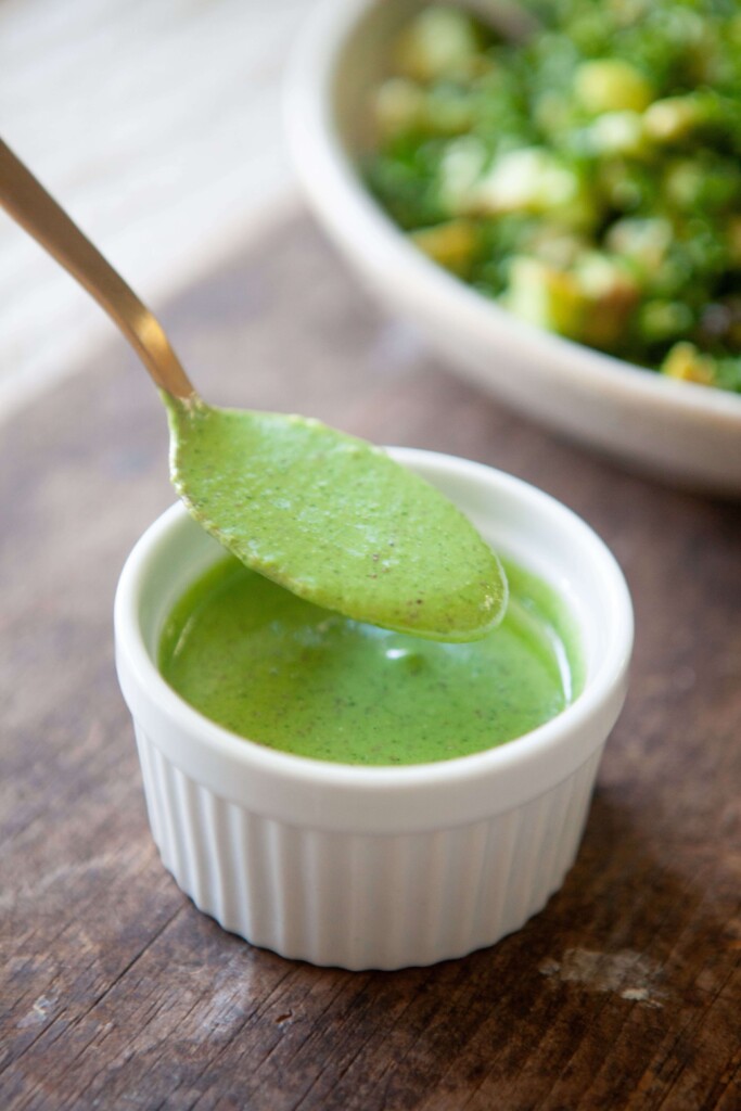Lemon balsamic cilantro dressing on gold spoon.