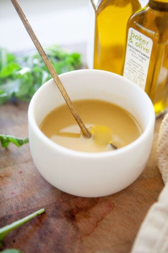 Sweet mustard vinaigrette in a small bowl with gold spoon.