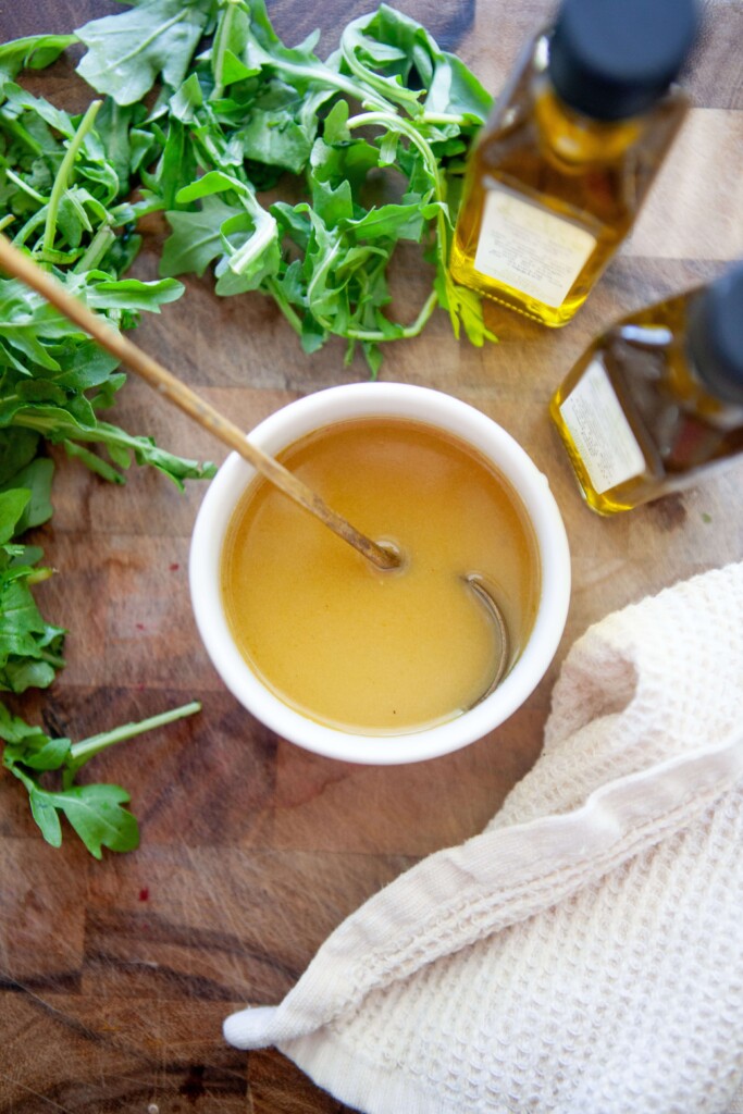 Sweet mustard vinaigrette in small bowl with a gold spoon.