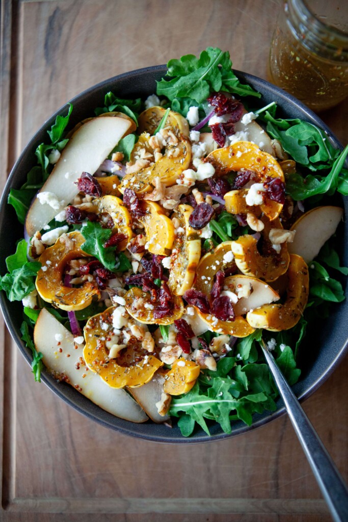 Roasted delicata salad in bowl with fork.