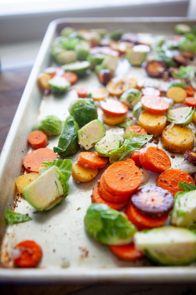 Brussel sprouts, carrots and shallots on baking dish before roasting.