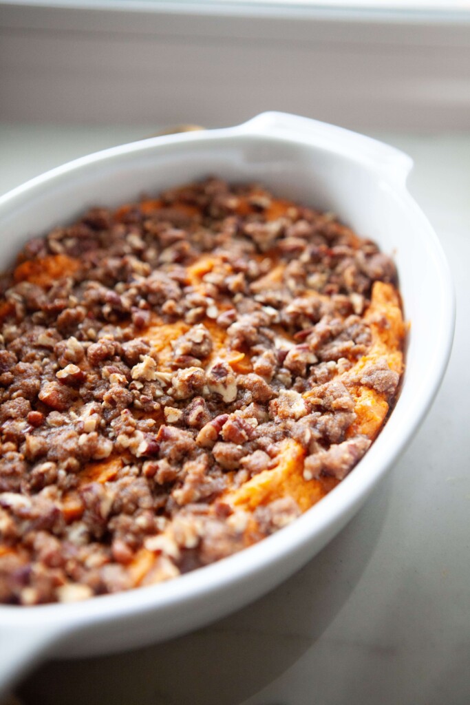 Healthier sweet potato casserole baked in white casserole dish.
