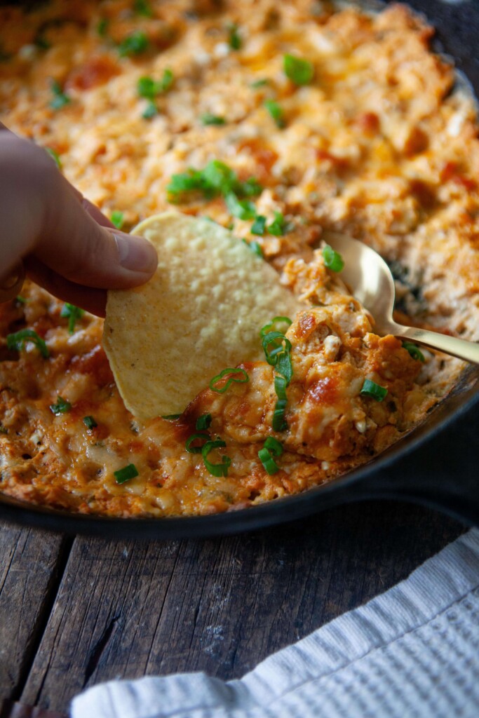 Chip dipping into healthy buffalo chicken dip.