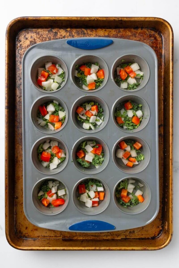 Diced veggies in the bottom of silicone mold.