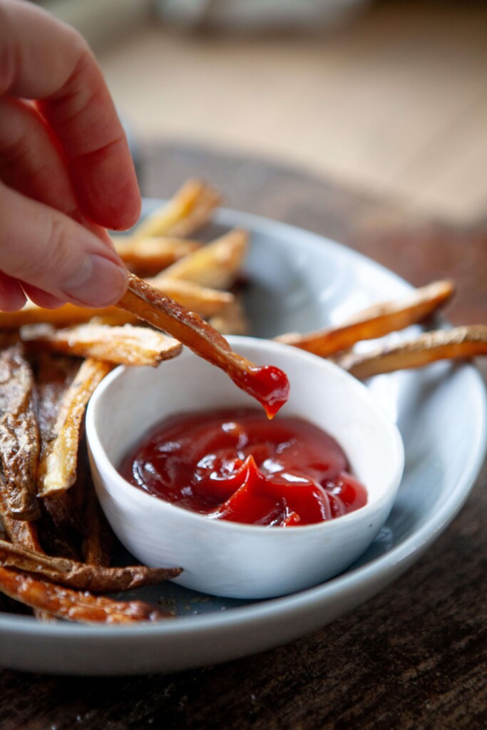Fry dipping into ketchup.
