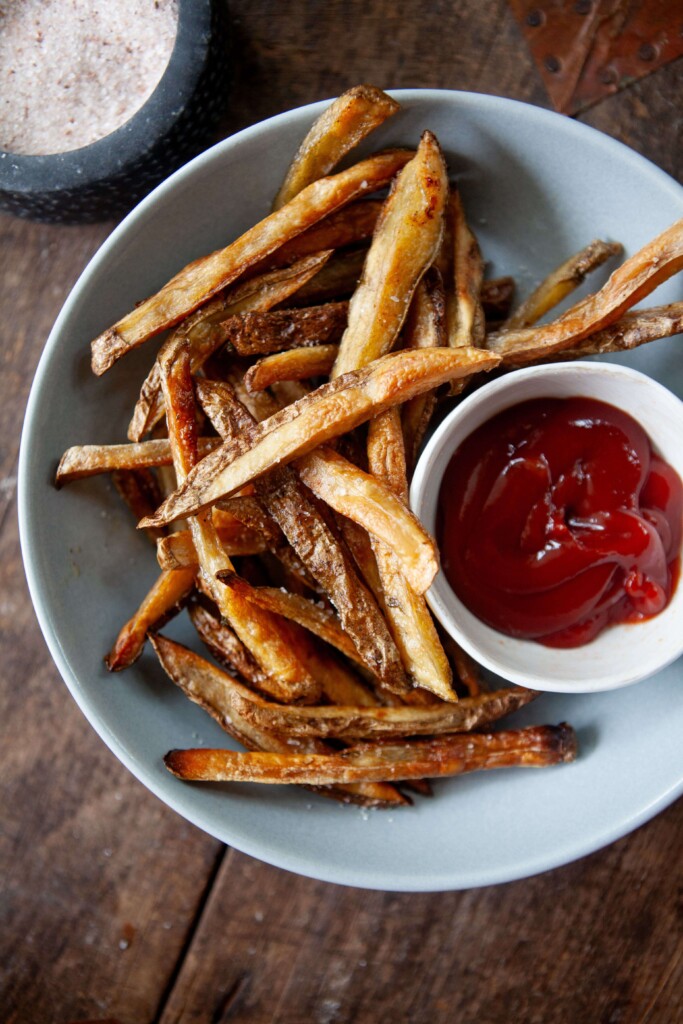 Healthy french fries in a bowl with a side of ketchup in a little bowl.