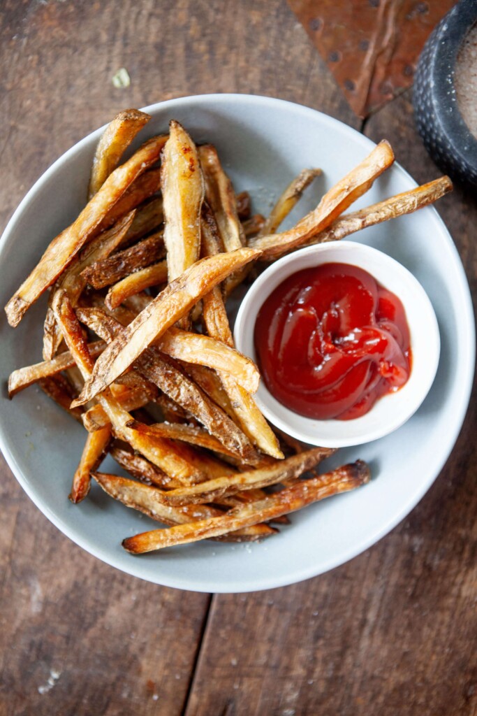 Air fried healthy fries with ketchup in a bowl.