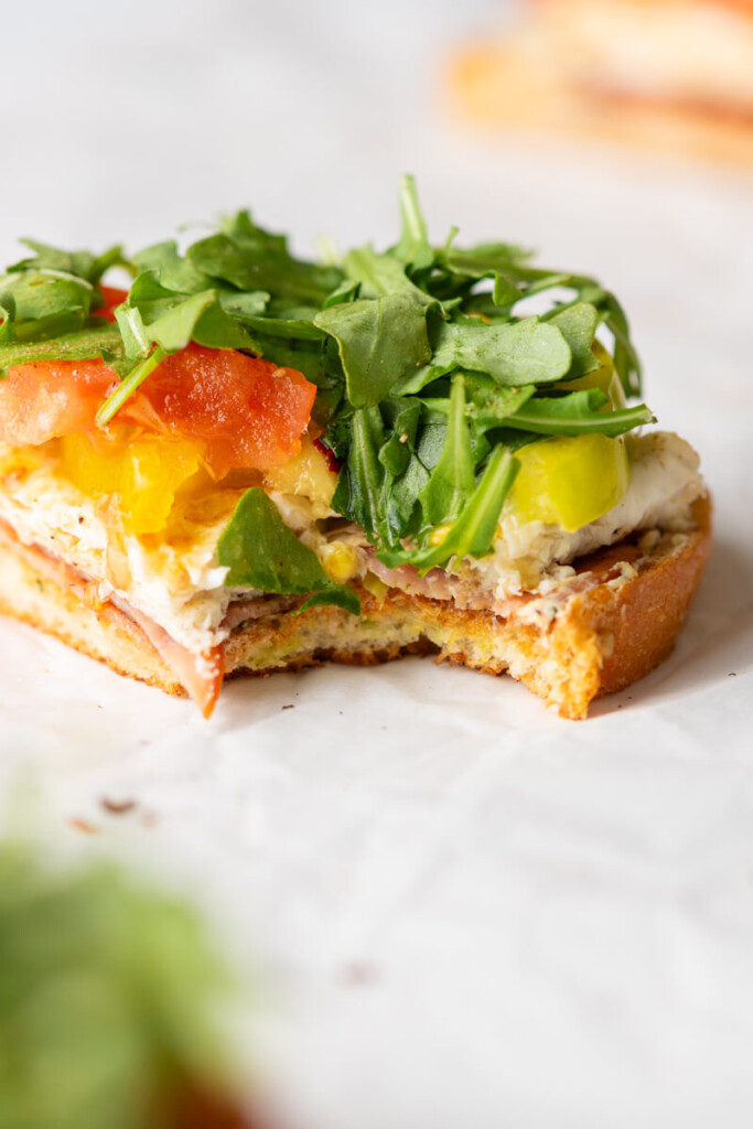 Bite taken out of tomato basil egg white toast.
