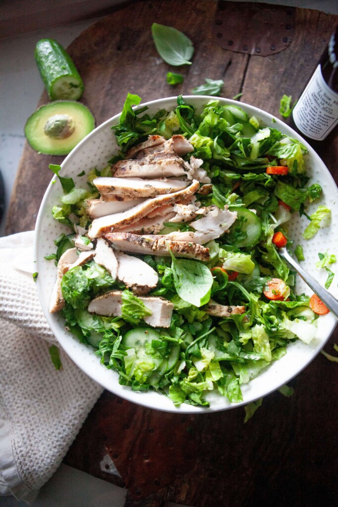 House salad topped with grilled chicken.
