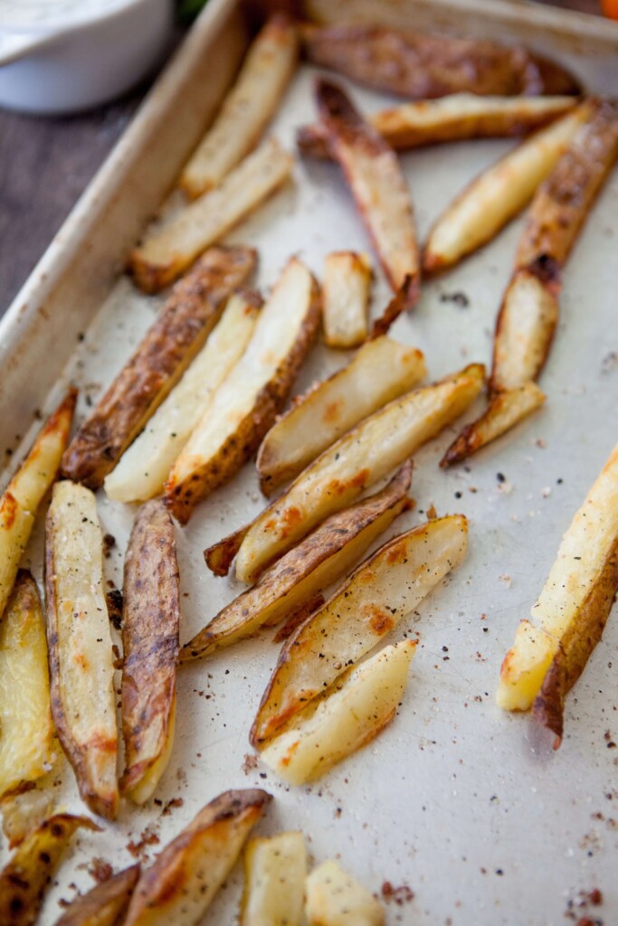 Oven roasted fries cooked on metal baking sheet.